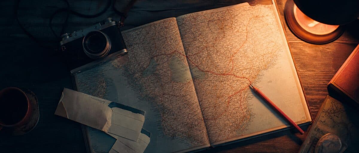 A planning desk with a paper map, a marked route, and travel notes